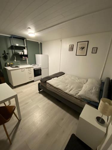 a small bedroom with a bed and a kitchen at K&F Apartment in Keflavík