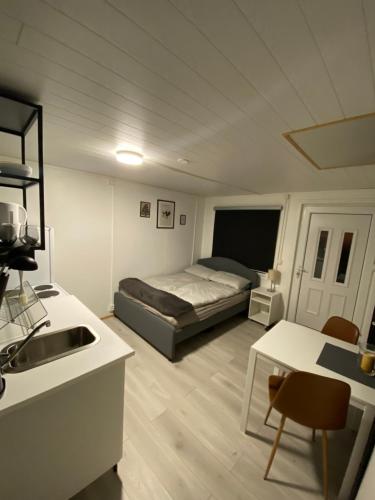 a bedroom with a bed and a table and a kitchen at K&F Apartment in Keflavík