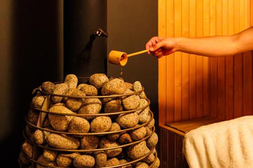 a person holding a spatula next to a pile of food at Hakuba Aurora Chalet by Jade Group in Hakuba