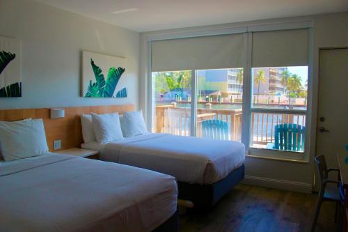 a hotel room with two beds and a balcony at Gilbert's Resort in Key Largo