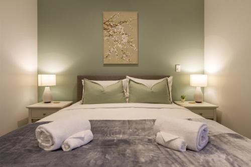 a bedroom with a large bed with towels on it at CBD Gem: Walk to everything, 3 bedroom 2 bath in Christchurch