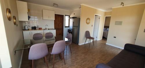 a kitchen and living room with a table and chairs at Cabañas Loteo Monaco, Angol in Angol