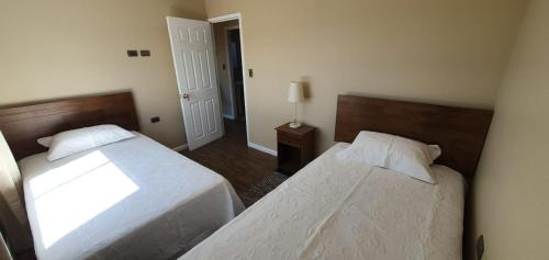 een slaapkamer met 2 bedden en een lamp erin bij Cabañas Loteo Monaco, Angol in Angol