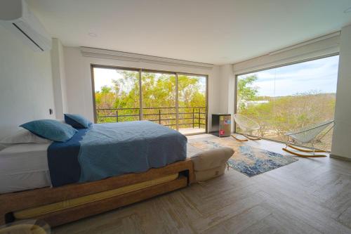 ein Schlafzimmer mit einem Bett und einem großen Fenster in der Unterkunft Casa privada en Isla Barú 5BR in Barú