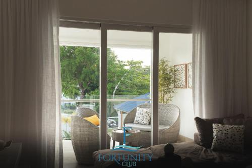 a living room with a sliding glass door with a table and chairs at Fortunity Club- Playa Dorada, Pto Plata in San Felipe de Puerto Plata
