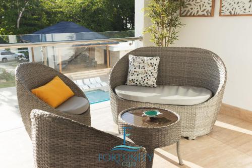 two wicker chairs and a table in a living room at Fortunity Club- Playa Dorada, Pto Plata in San Felipe de Puerto Plata