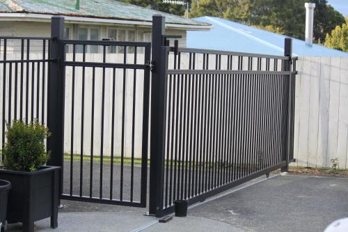a black metal fence in front of a house at Self contained Studio with Ensuite, WIFI & Kitchenette in Auckland