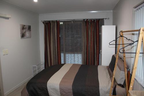 a bedroom with a bed and a window at Self contained Studio with Ensuite, WIFI & Kitchenette in Auckland