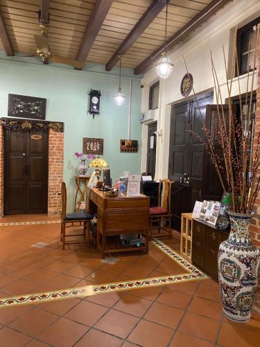 a room with a desk and a vase on the floor at ke-lan-tan House in George Town