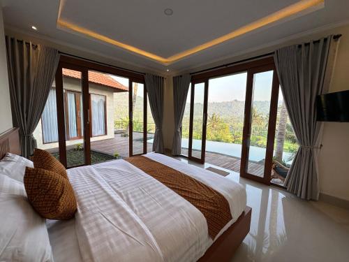 sypialnia z łóżkiem i dużymi szklanymi oknami w obiekcie Nana Suites Villa w mieście Sidemen