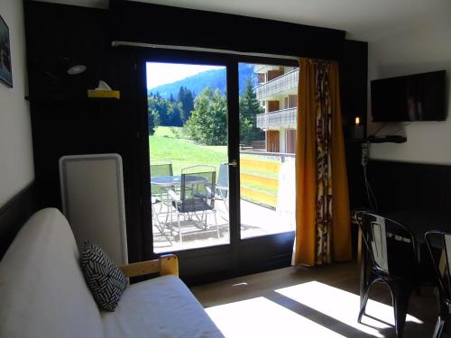 Cette chambre comprend un lit et offre une vue sur un balcon. dans l'établissement Appartement cosy 2 pièces Châtel - Proche remontées, 4 pers., terrasse, parking, lave-linge - FR-1-676-131, à Châtel