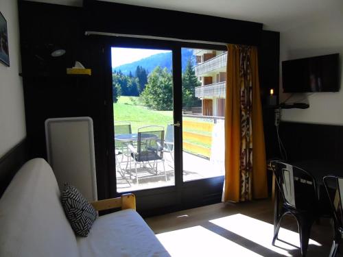 a room with a bed and a view of a balcony at Appartement Châtel, 2 pièces, 4 personnes - FR-1-676-131 in Châtel