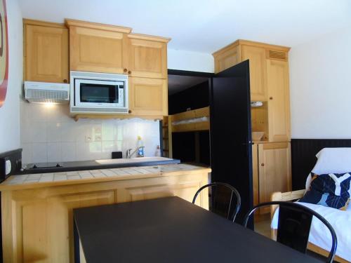 une cuisine avec un évier et un micro-ondes dans l'établissement Appartement cosy 2 pièces Châtel - Proche remontées, 4 pers., terrasse, parking, lave-linge - FR-1-676-131, à Châtel