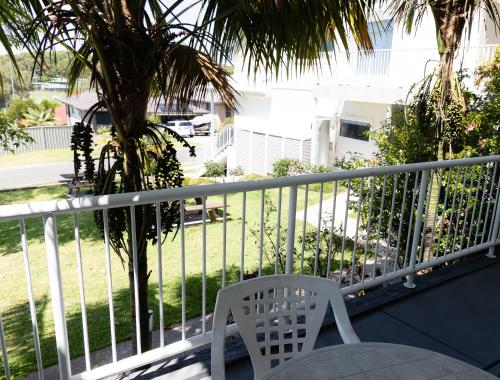 a white chair sitting on top of a balcony at Aston Hill Motor Lodge in Port Macquarie