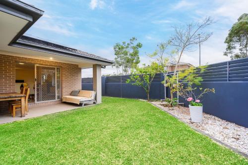 a backyard with a fence and green grass at Jordan Springs classic sweet 3Br home WiFi&Parking in Kingswood