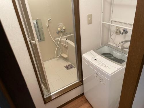 a small bathroom with a shower and a washing machine at STAY Moiwayama201 in Sapporo