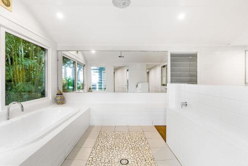 a white bathroom with a tub and a large window at A Perfect Stay - Aria in Nashua