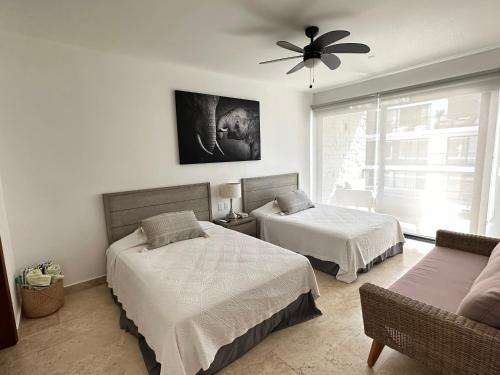 a bedroom with two beds and a ceiling fan at New Condo with Pool, Gym, A/C, WiFi, King Size bed in Cancún