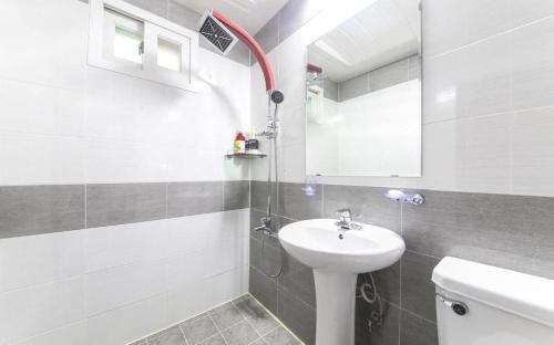 a white bathroom with a sink and a toilet at Paldo Motel in Yeosu