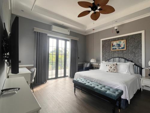 - une chambre avec un lit et un ventilateur de plafond dans l'établissement Vườn Vua Resort & Sun Villas Khu Thanh Liên, à Ðồng Phú