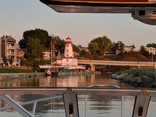 a boat in the water with a lighthouse in the background at Inn at the Harbour in Kincardine