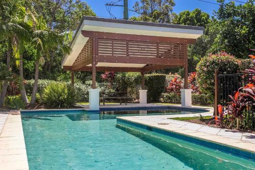 a swimming pool with a pergola next to a house at Drift - 3 BR home near town & beach with pool in Byron Bay