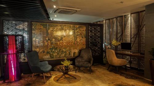 a room with a large painting on the wall at The Chi Boutique Hotel in Hanoi