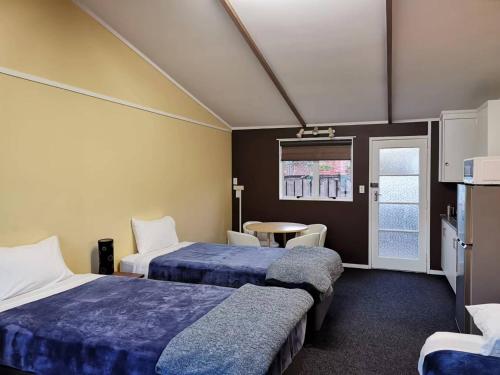 Säng eller sängar i ett rum på Parakai Geothermal Motel
