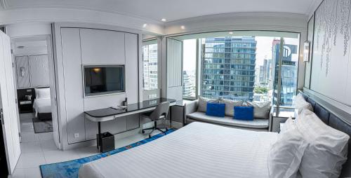 - une chambre avec un lit et un bureau avec un ordinateur dans l'établissement Grande Centre Point Sukhumvit 55 Thong Lo, à Bangkok