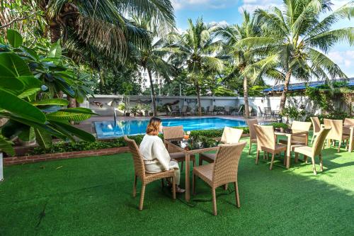 a woman sitting at a table next to a pool at Baan Thai Boutique in Bangkok