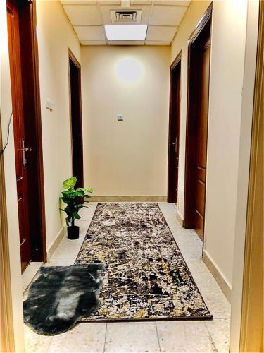 un pasillo con una alfombra en el suelo de una habitación en AlAIN GUEST HOUSE, en Al Ain