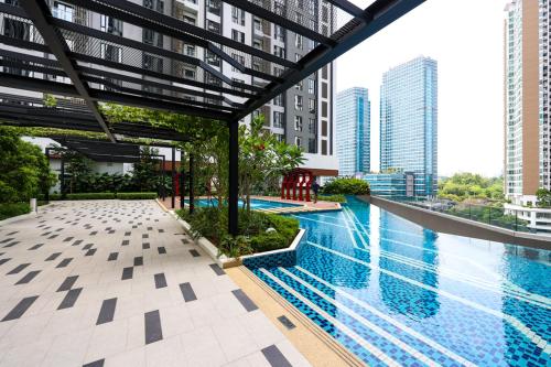 a swimming pool in the middle of a city with tall buildings at Sentral Suites Kl Sentral By Luxe Home in Kuala Lumpur
