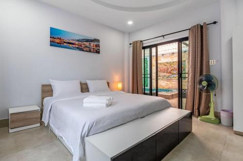 a white bedroom with a large bed and a window at Luxury Thai Style Pool Villa in downtown Pattaya, close to Walking Street in Pattaya South