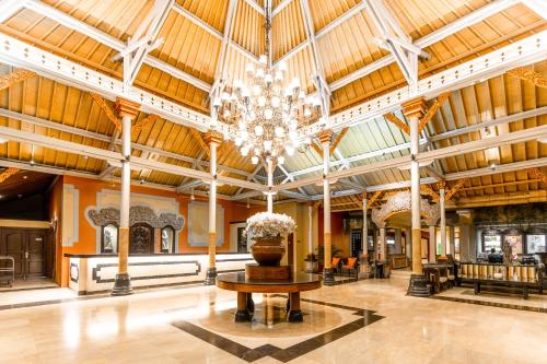 eine große Lobby mit einem Kronleuchter und einem Tisch in der Unterkunft Bali Garden Beach Resort in Kuta