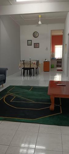 a room with a table and a carpet on the floor at Inap Mudah in Seri Iskandar