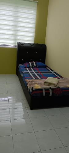 a bed sitting in a room with a window at Inap Mudah in Seri Iskandar