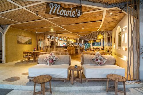龍目島的住宿－Mowies Gili Air，一间商店,里面摆放着两张沙发和两张桌子及椅子