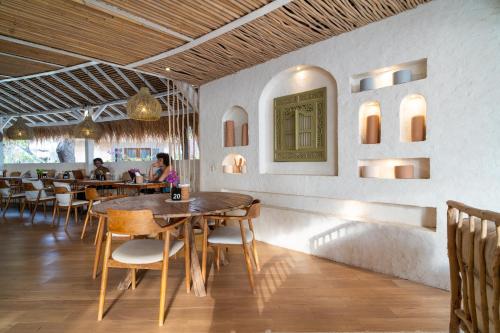 un restaurante con mesas y sillas y gente sentada a su lado en Mowies Gili Air, en Gili Air