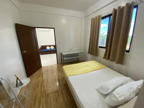 een kleine slaapkamer met een bed en een raam bij Casa Concetta Apartelle with Pool in Manolo Fortich