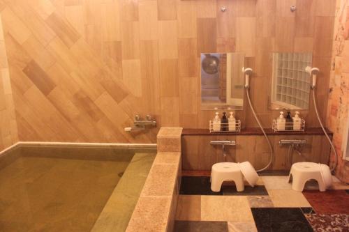 a bathroom with a shower and two stools at Nagashima cottage - Vacation STAY 9014 in Kuwana