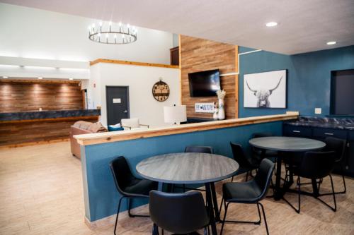 een bar met 2 tafels en stoelen in een kamer bij OK Welcome Home Hotel in Alva
