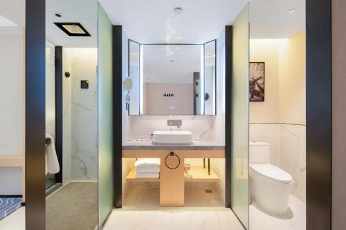 uma casa de banho com um lavatório e um WC em Guangzhou Baiyun Airport COCO Hotel em Huadu