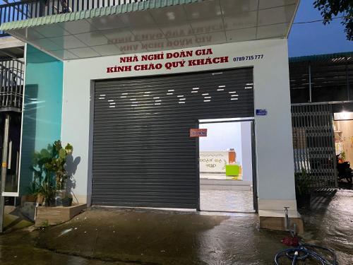 una grande porta del garage di metallo con un cartello sopra di Nhà Nghỉ Đoàn Gia a Dồng Xoài