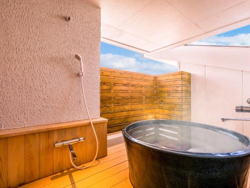 a bath tub sitting on top of a wooden floor at Yukai Resort Premium Toba Saichoraku in Toba