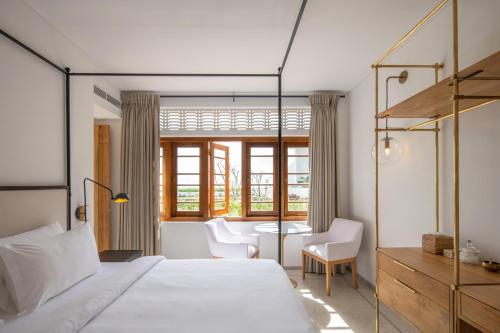a bedroom with a bed and a table and chairs at The Charleston in Galle