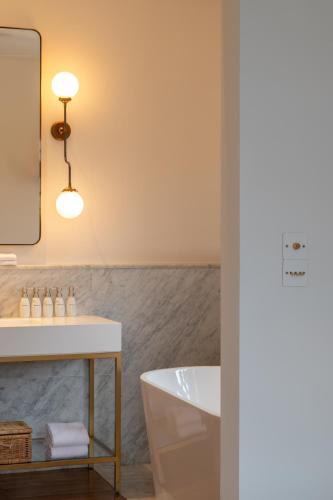 a bathroom with a tub and a sink and a mirror at The Charleston in Galle