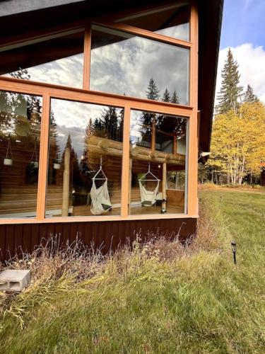 a house with a large window on the side of it at 7 Acres Forest - Skiing Close - Privacy - Theatre in Golden