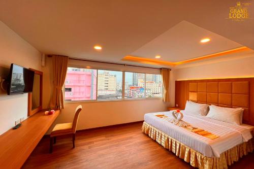 芭達雅中心的住宿－The Grand Lodge Pattaya，一间设有大床和窗户的酒店客房