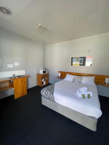 a bedroom with a large bed with a white bedspread at Mountain View Motel in Queenstown