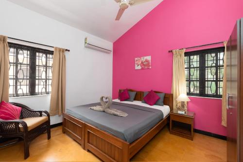 カラングートにあるVilla Calangute Phase 3 & 4- Private Luxury Villa in Goaのピンクの壁、ベッド1台付きのベッドルーム1室